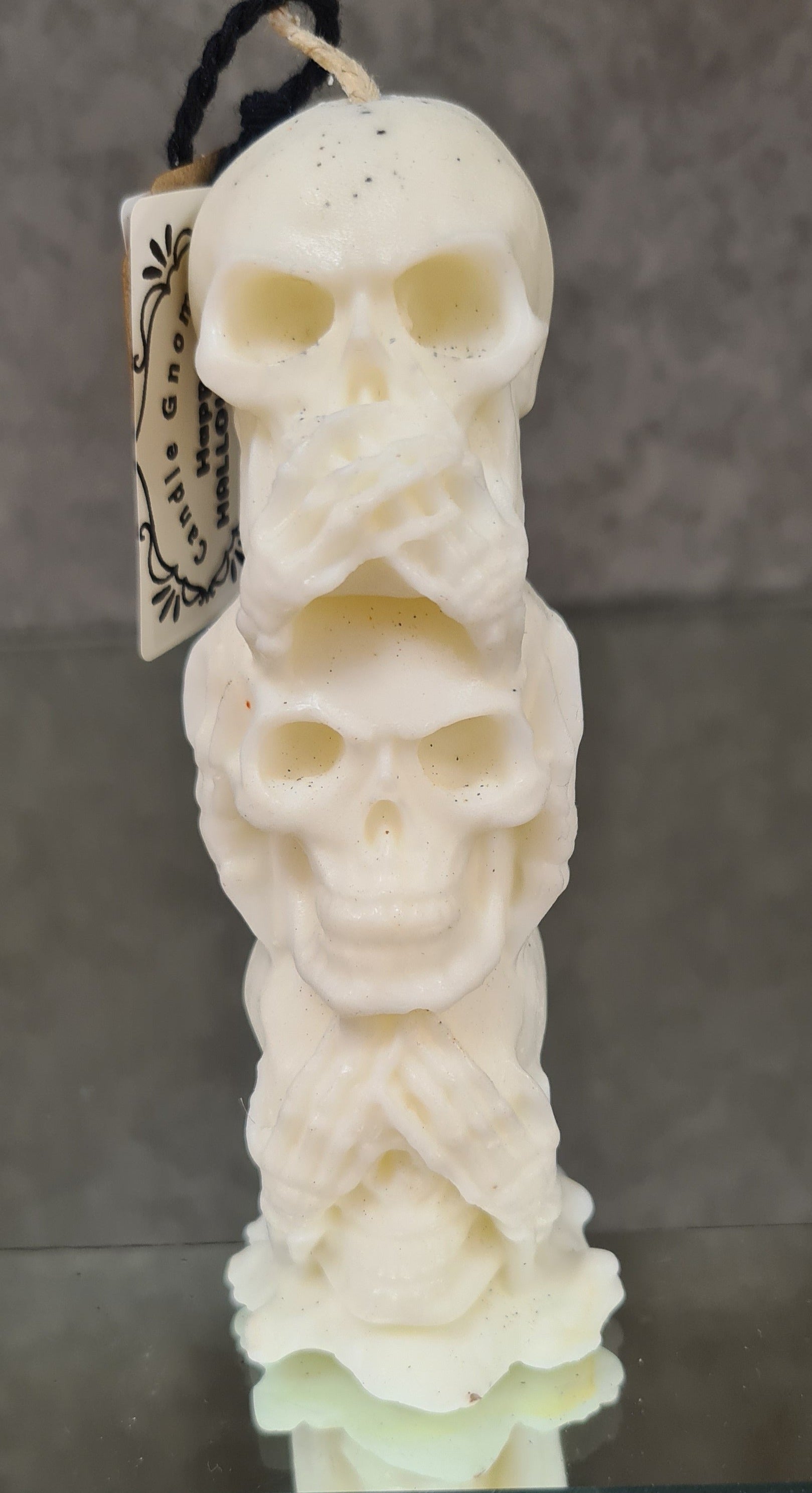 Candle trio with cascading skulls in a magical setting.