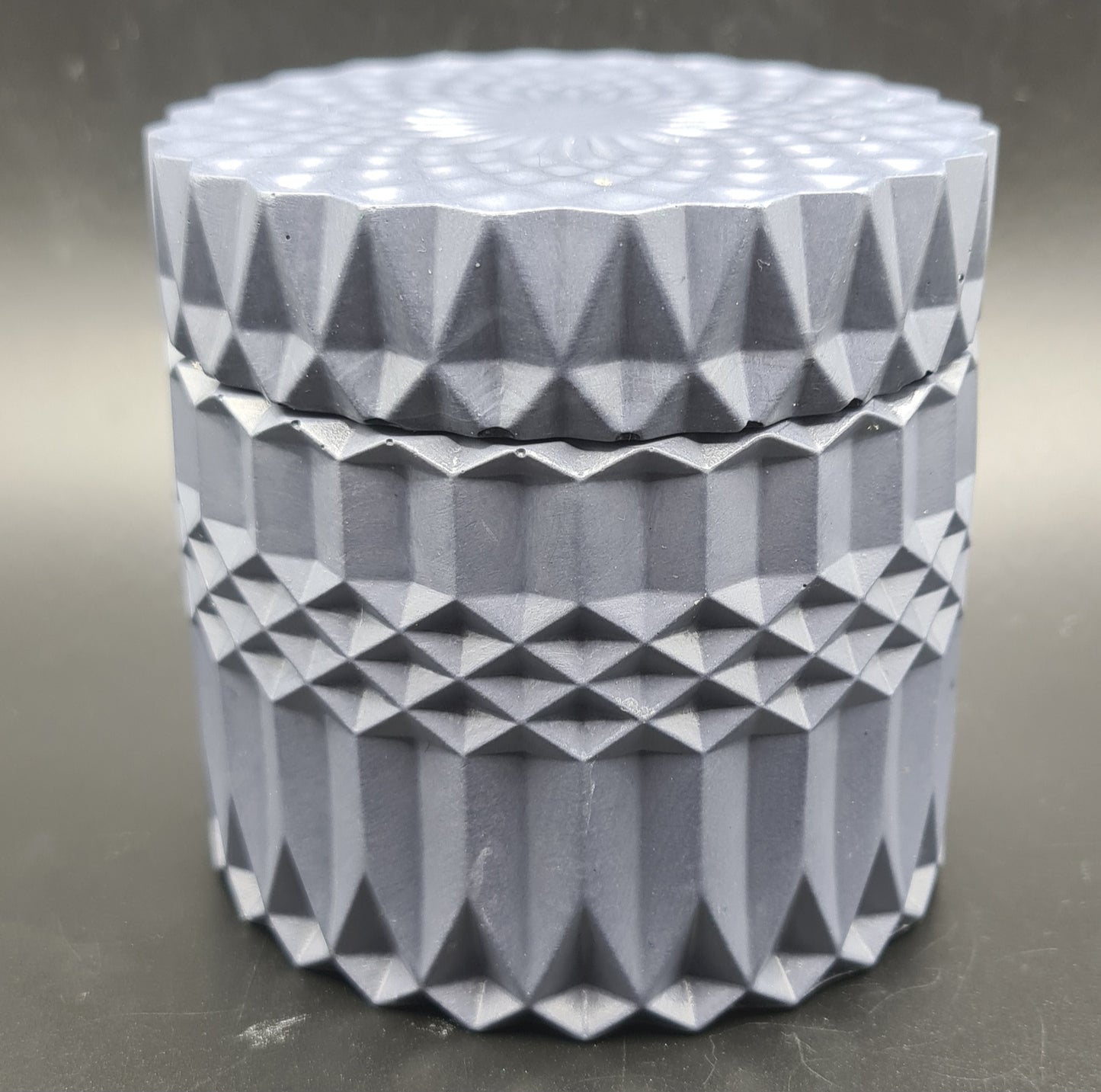 Elegant hand-poured candle in a stylish geometric pot design.